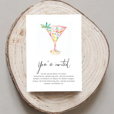 Watercolor cocktail glass with "You're invited" text on a wood slice.