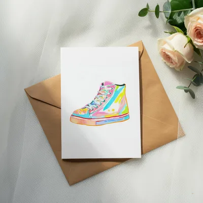 Colorful high-top sneaker illustration on card, resting on brown envelope with roses.