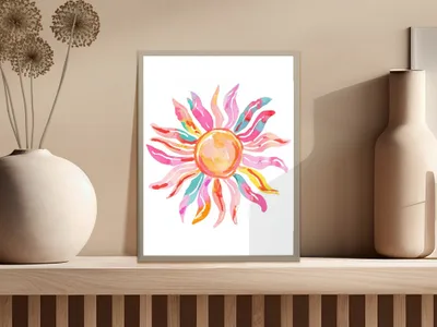 Colorful sun art print with pink, yellow, and blue rays on a shelf.
