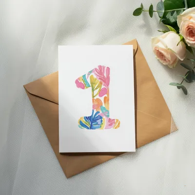 Card with colorful "1" design on brown envelope with roses.