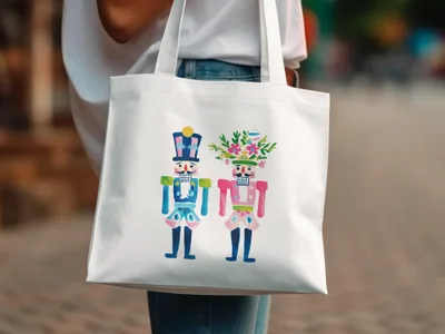 Two watercolor nutcracker figures with floral headdresses on a white tote bag.
