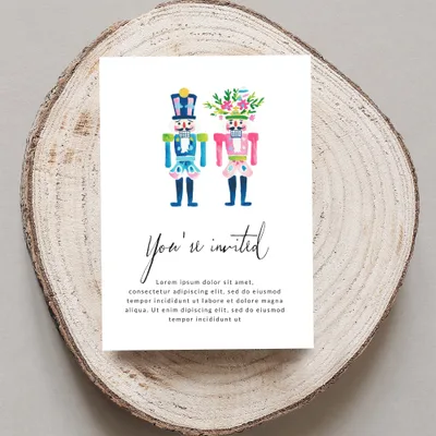 Nutcracker invitations with "You're invited" text on a wood slice.