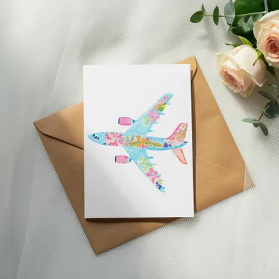 Card featuring a watercolor airplane with floral details on a brown envelope.