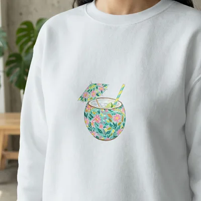 White sweatshirt with embroidered tropical drink featuring colorful floral pattern.