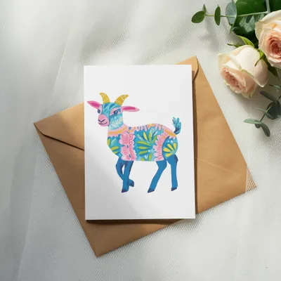 Colorful illustrated goat on a card with roses and a brown envelope.