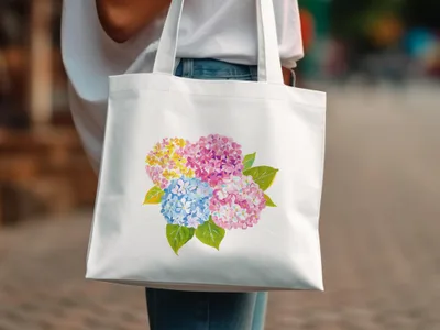 White tote bag with watercolor hydrangea flowers in pink, yellow, and blue.