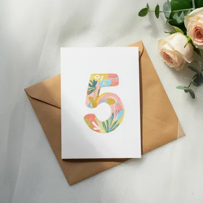 Card with colorful floral "5" design on brown envelope.
