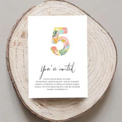 Card with "5" and "You're invited" text, on a wooden slice.