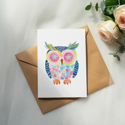 Whimsical watercolor owl illustration on a card with pink roses and greenery.