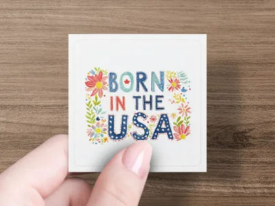 Square sticker with "BORN IN THE USA" text and floral accents.