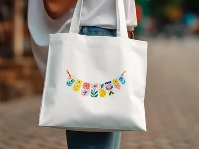 White canvas tote bag with a colorful floral garland illustration.