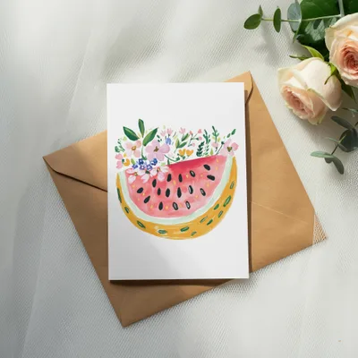 Watercolor watermelon slice with floral accents on a brown envelope.