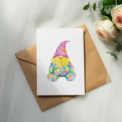 Watercolor gnome with colorful patterned hat and clothing on a brown envelope.