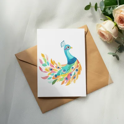 Watercolor peacock illustration on a card with roses and eucalyptus.