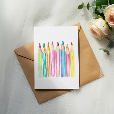 Watercolor illustration of a row of colorful pencils on a card.