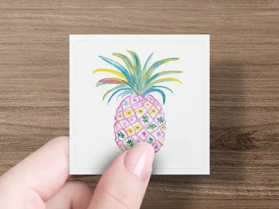 Watercolor pineapple with floral pattern on white card held by hand.