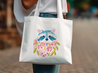 White tote bag with illustration of a raccoon wearing a floral garland.