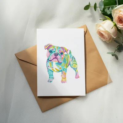 Watercolor bulldog illustration on a card atop a brown envelope.