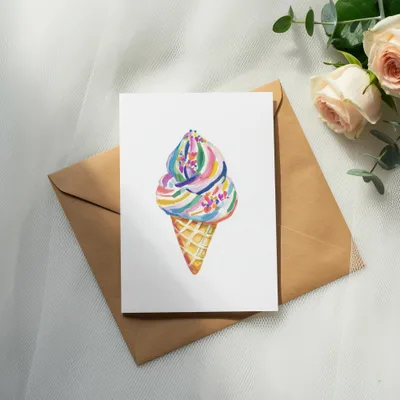 Watercolor ice cream cone with colorful sprinkles on a card.