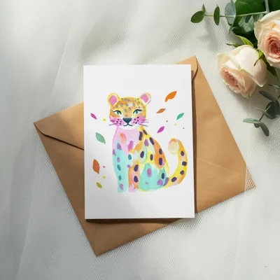 Watercolor illustration of a colorful leopard on a card with roses and eucalyptus.