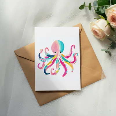 Colorful watercolor octopus illustration on a card, atop an envelope.