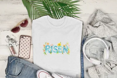 White t-shirt with "Risen" in watercolor floral lettering.