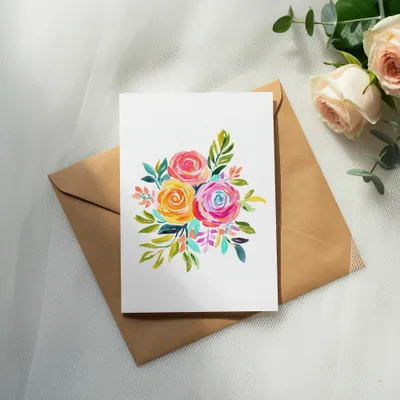 Watercolor floral bouquet illustration on card over brown envelope with roses.