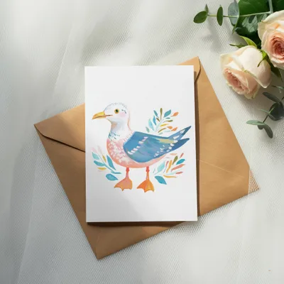 Watercolor illustration of a seagull on a card with a kraft envelope and roses.