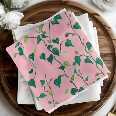 Pink fabric with green vine pattern, folded on white napkins.