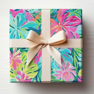 Gift box wrapped in colorful floral paper with a light beige ribbon.