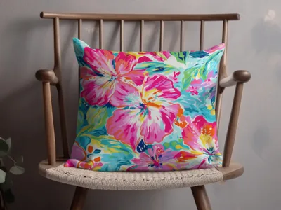 Bright floral throw pillow with pink, blue, and yellow hibiscus flowers.