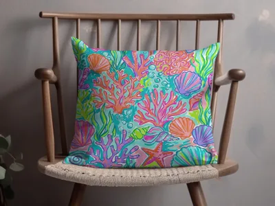 Pillow with a vibrant coral reef design featuring shells, starfish, and sea plants.