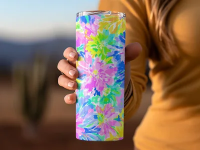 Tumbler with bright floral pattern held by a person.