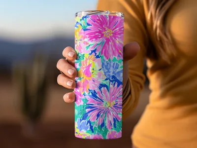 Woman's hand holding a brightly colored floral patterned tumbler.