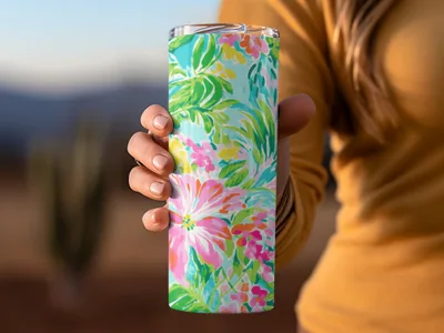 Tumbler with bright pink and blue floral pattern held by a person.