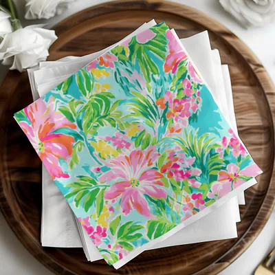 Colorful floral print napkins on a wooden tray with white napkins.