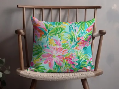 Bright floral throw pillow with pink, coral, and green blossoms on turquoise background.