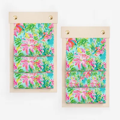 Fabric swatches with bright floral print on wooden clipboards.