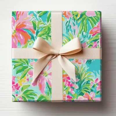Gift wrapped box with vibrant floral pattern and beige ribbon bow.