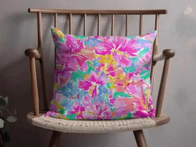 Pillow with a vibrant, abstract floral pattern in pinks and blues.