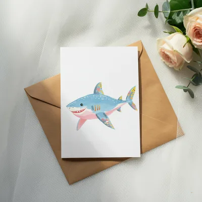 Illustration of a friendly blue shark with colorful patterns on a white card.