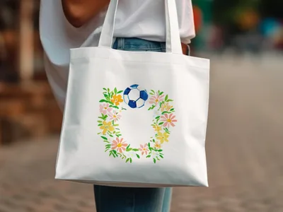 White tote bag with a floral wreath and a soccer ball design.