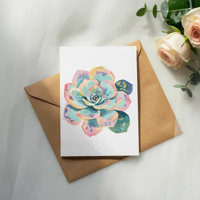 Watercolor succulent on card placed on envelope with roses and eucalyptus.
