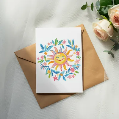 Watercolor sun with colorful floral wreath on a blank card and envelope.