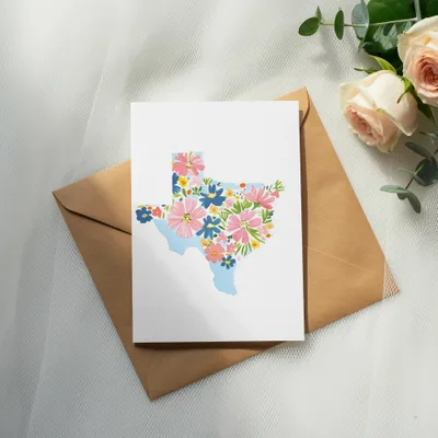Card with Texas outline filled with colorful flowers on an envelope.