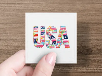 "USA" text in colorful floral pattern held by a hand.