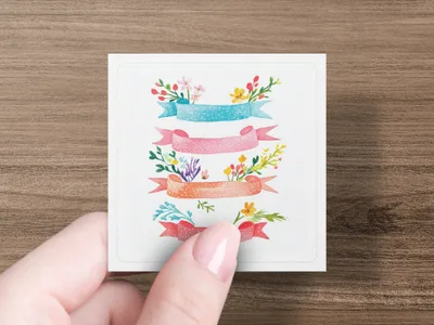 Four decorative watercolor banners with floral accents on a white card held by a hand.