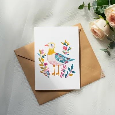 Watercolor painting of a bird with colorful flowers on a kraft envelope.