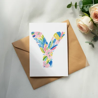 Watercolor letter Y with floral accents on an envelope with roses.