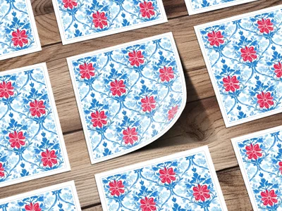 Blue and red floral pattern on white cards scattered on a wooden surface.
